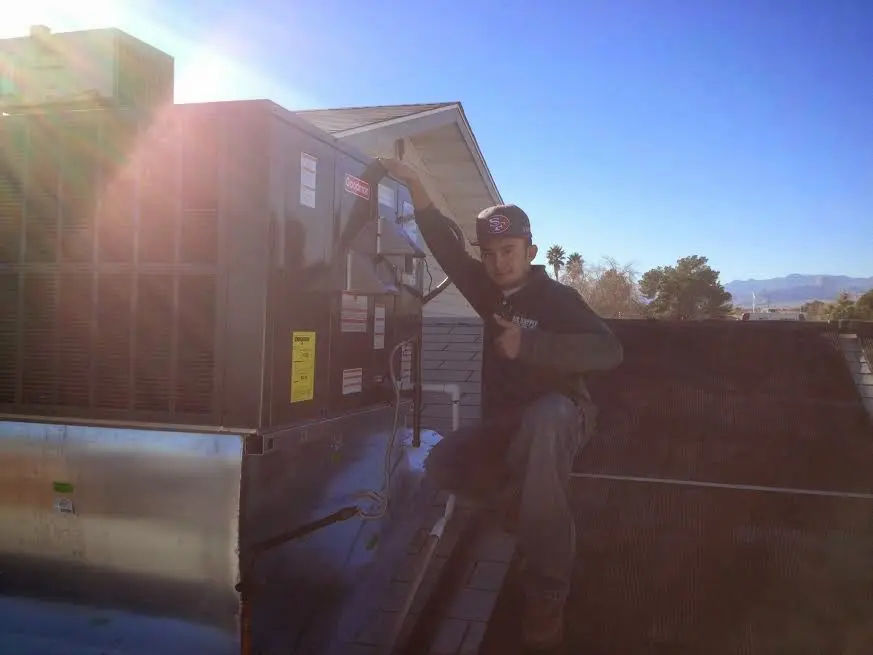 HVAC technician performing Air Duct Cleaning on a rooftop unit in Lutherville